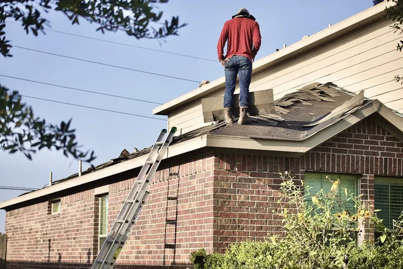 Professional roofer working on a residential roof in Carriagehouse